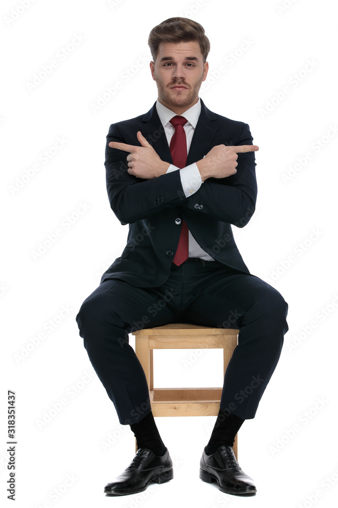 elegant young businessman pointing fingers to both sides elegant young businessman pointing fingers to both sides