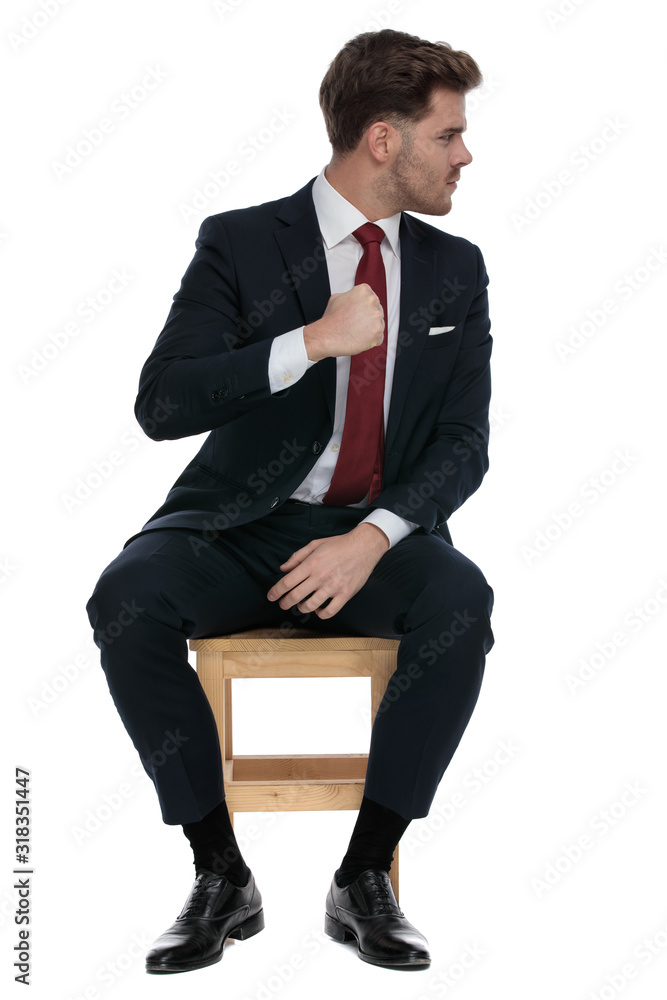 angry young businessman looking to side and punching angry young businessman looking to side and punching