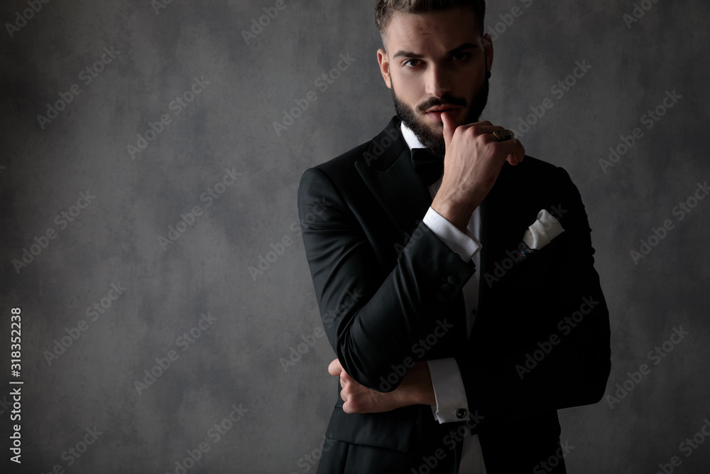 businessman standing with arms folded and touching lips seductive businessman standing with arms folded and touching lips seductive