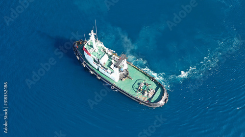 Aerial drone top down photo of tug boat cruising in industrial carrier logistics terminal © aerial-drone