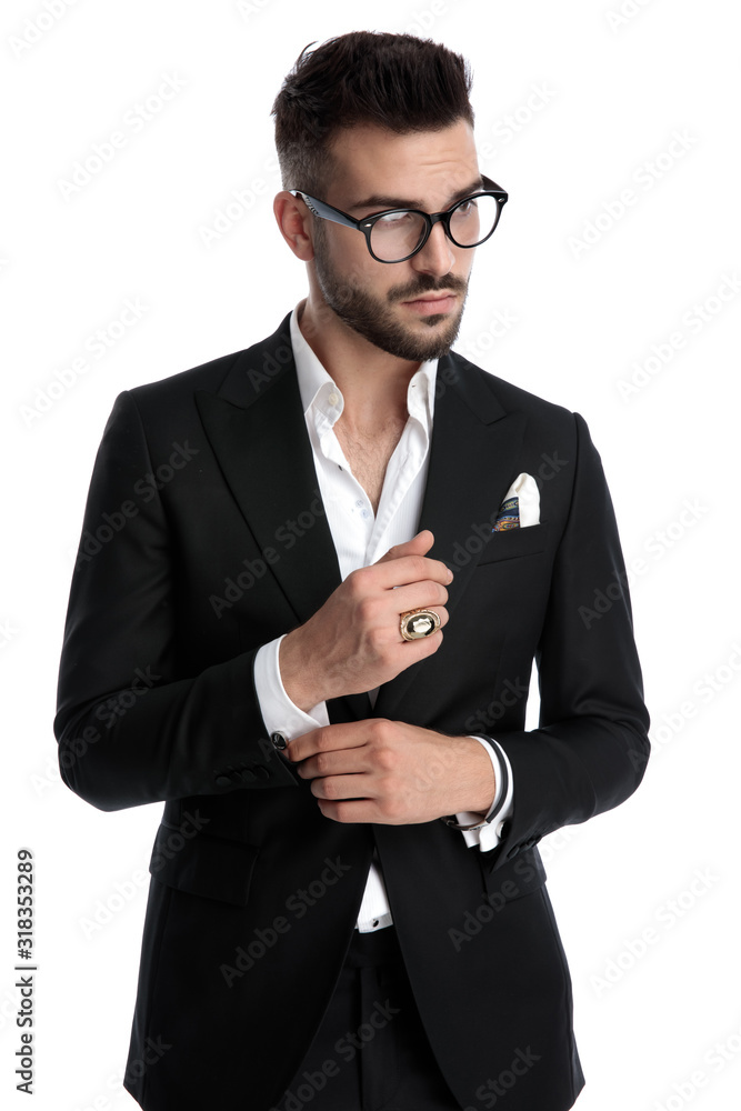 businessman standing and fixing sleeve while looking away pensive businessman standing and fixing sleeve while looking away pensive