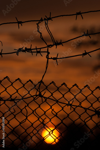 Sunset behind a barbed fence