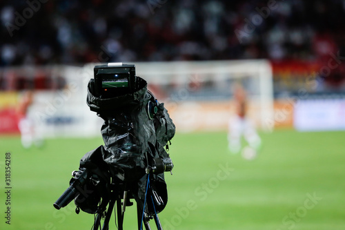 TV camera at the stadium, broadcasting during a football (soccer) match