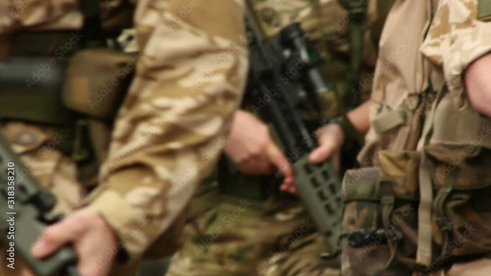 Army Soldiers marching through the streets with guns / rifles. They march in formation in camouflage. Close up of arms Army Soldiers marching through the streets with guns / rifles. They march in formation in camouflage. Close up of arms