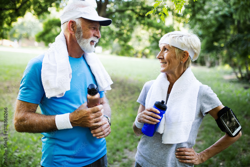 Senior couple jogging and running outdoors in nature