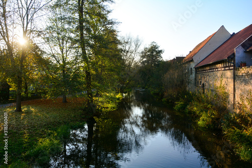 Wallpaper Mural Creek with nature and old houses in the evening light,with sun Torontodigital.ca
