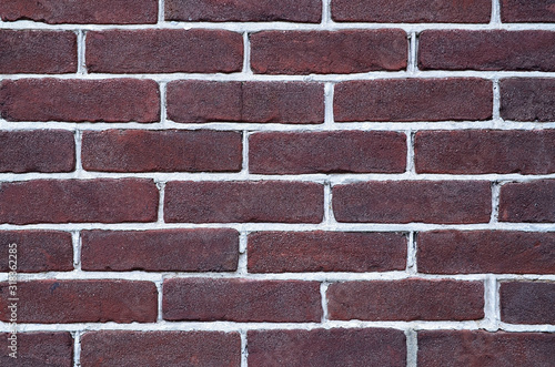 Brick wall background texture.Close-up of a facade panel of a brickwork of dark brown color.Selective focus.