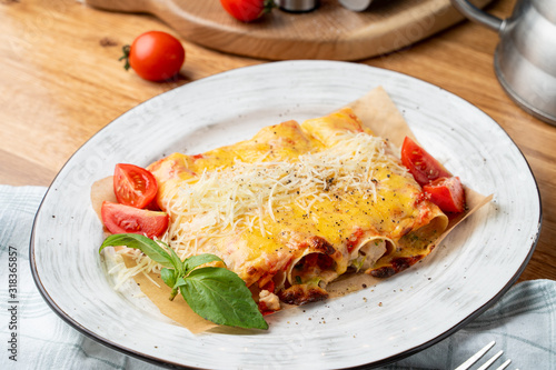 Cannelloni stuffed with turkey and vegetables, with melted cheddar and mozzarella cheese