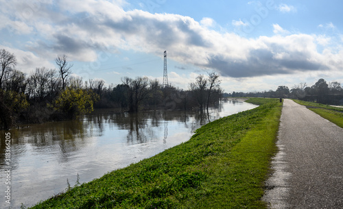 Paved bike path on top of earthen dike levee along Mississippi River in Louisiana 