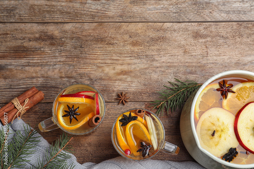 Aromatic mulled wine on wooden table, flat lay. Space for text