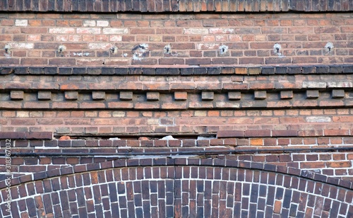 Old red brick facade of building - details of brick walls, cornice photo