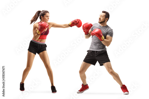 Young woman punching a man with boxing gloves