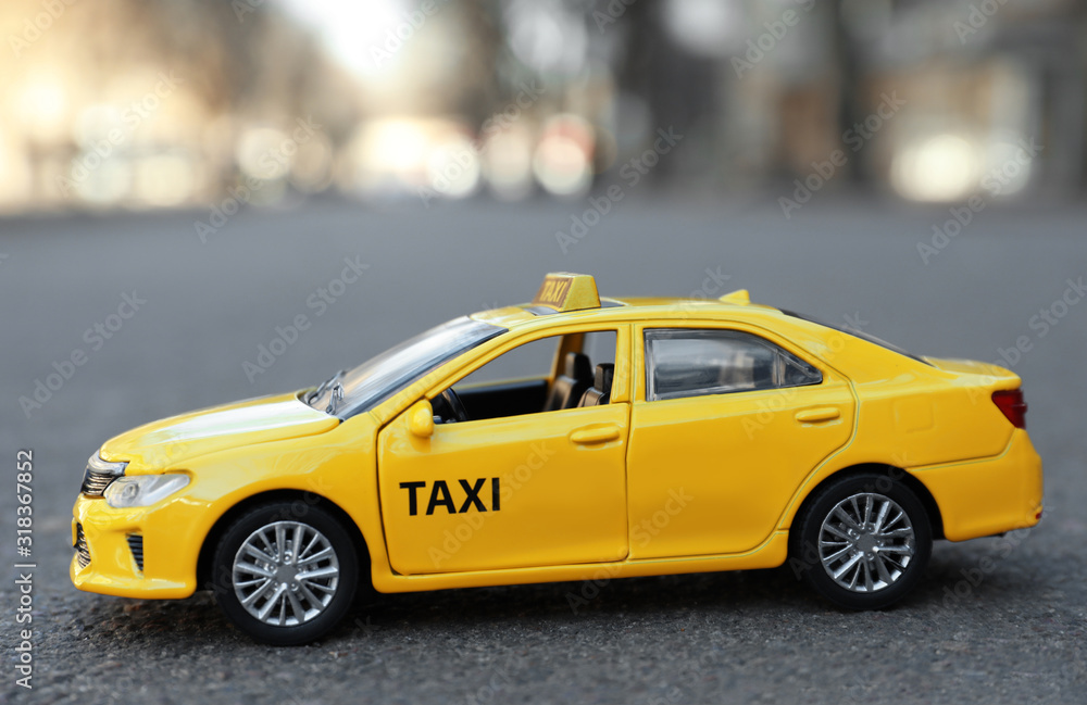 Yellow taxi car model on city street