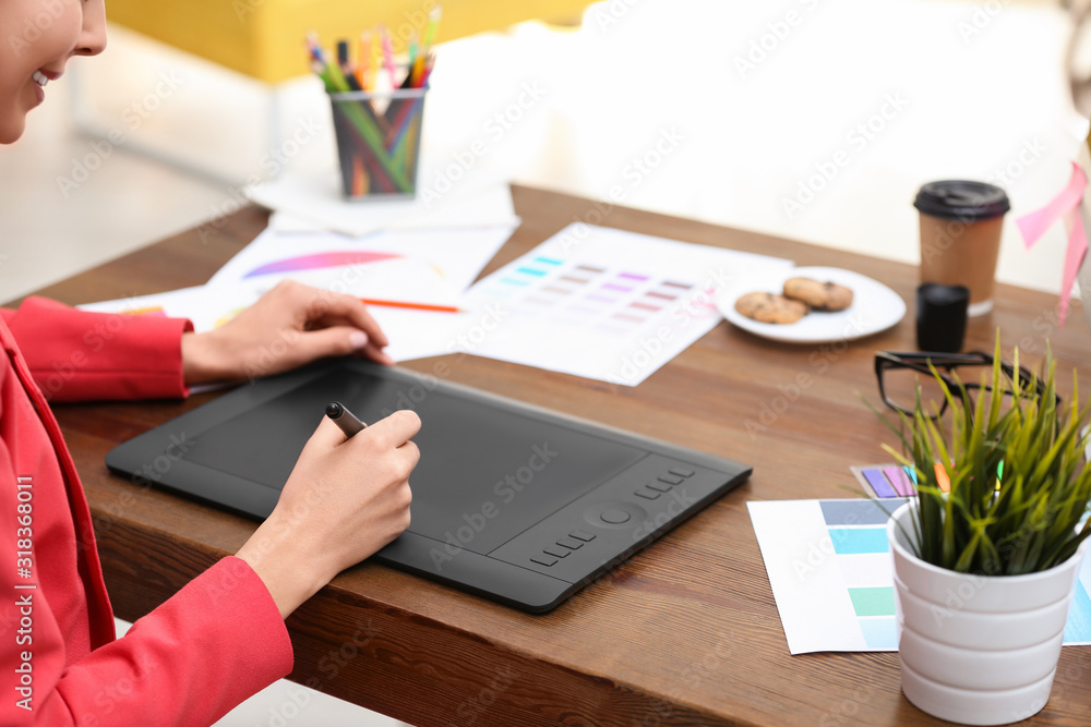 Female designer working at desk in office, closeup Female designer working at desk in office, closeup