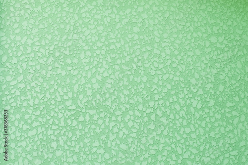 Old peeling plastered surface in green. For background and texture