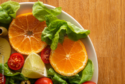 Vegetable Salad with tomato  orange  olive  spinach  lemon  kiwi  