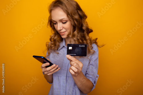 Shopping online concept. Happy woman holding phone and credit card isolated