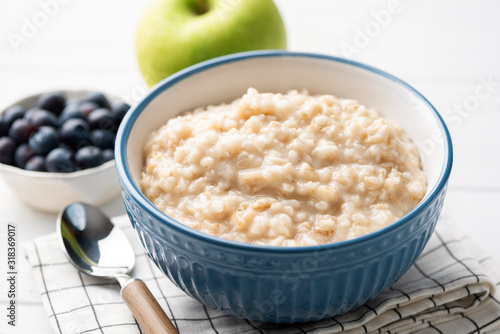 Healthy breakfast oatmeal porridge in bowl. Warm porridge oats, vegan vegetarian weight loss dieting breakfast food photo