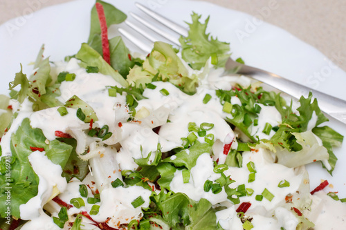 Healthy salad with feta cheese cubes and herbs.