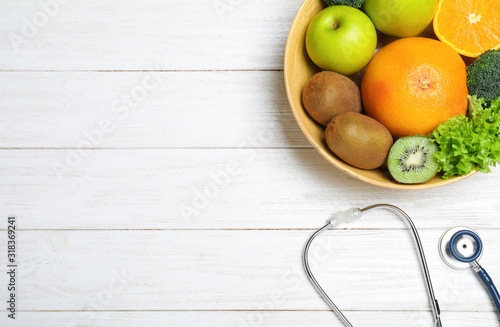 Fruits, vegetables and stethoscope on white wooden background, flat lay with space for text. Visiting nutritionist
