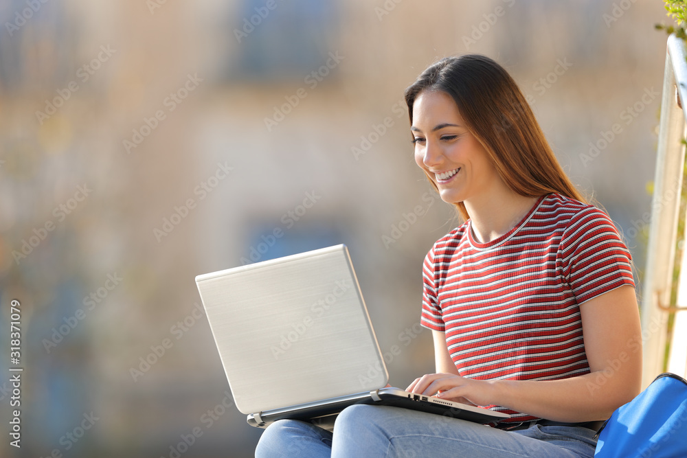 Happy student e-learning using laptop in a campus Happy student e-learning using laptop in a campus