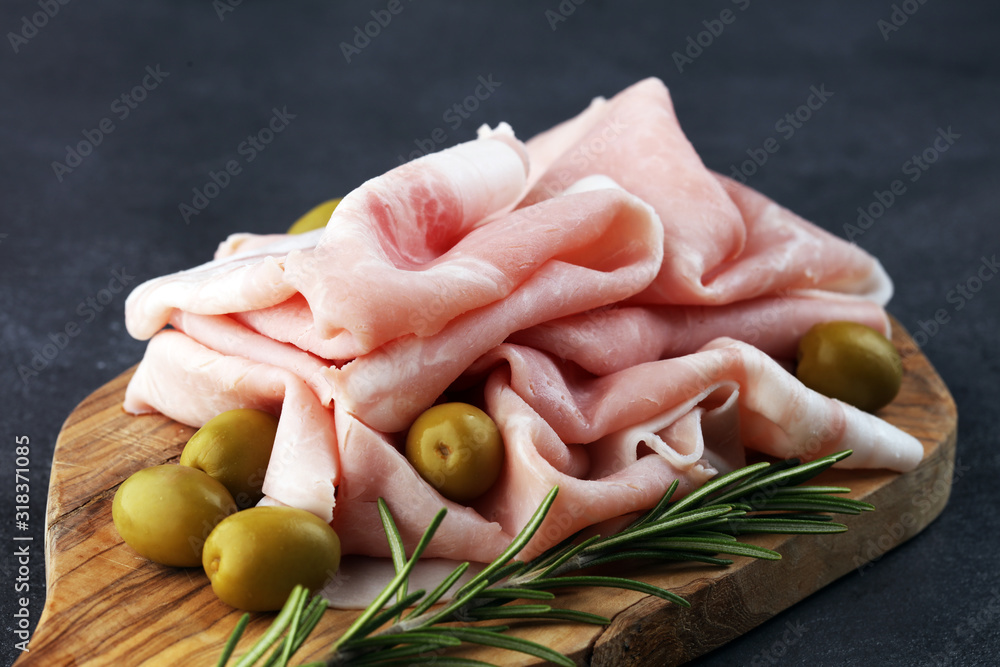 Sliced ham on wooden background. Fresh prosciutto. Pork ham sliced. pork meat cutting