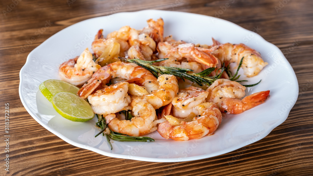 Fried or Roasted tiger big shrimps in plate with spice, lime, rosemary and lemon. Grilled seafood. Healthy food. Prawns Scampi traditional dish. Appetizer langoustines.Top view. Space for text Fried or Roasted tiger big shrimps in plate with spice, lime, rosemary and lemon. Grilled seafood. Healthy food. Prawns Scampi traditional dish. Appetizer langoustines.Top view. Space for text