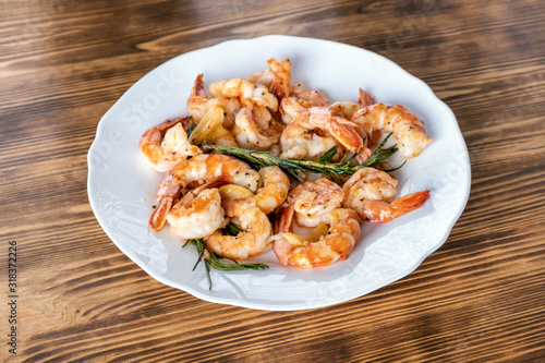 Fried or Roasted tiger big shrimps in plate with spice, lime, rosemary and lemon. Grilled seafood. Healthy food. Prawns Scampi traditional dish. Appetizer langoustines.Top view. Space for text