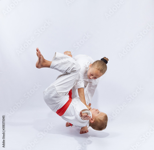 The girl with a white belt makes throws judo photo