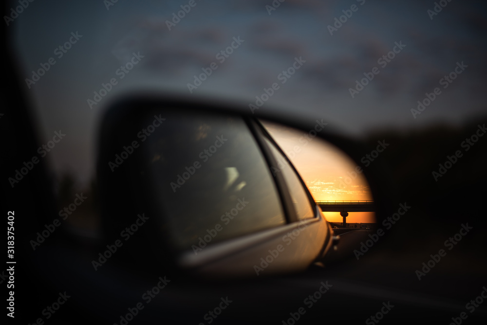 sunset vivid reflection seen through car side mirror highway space for text travel family fun concept