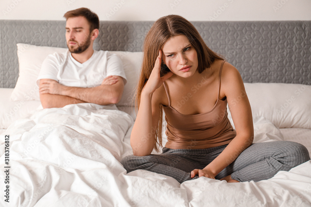 Unhappy couple with relationship problems after quarrel in bedroom