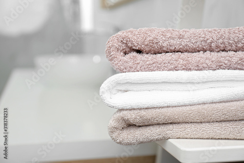 Fresh laundry on table in bathroom, closeup