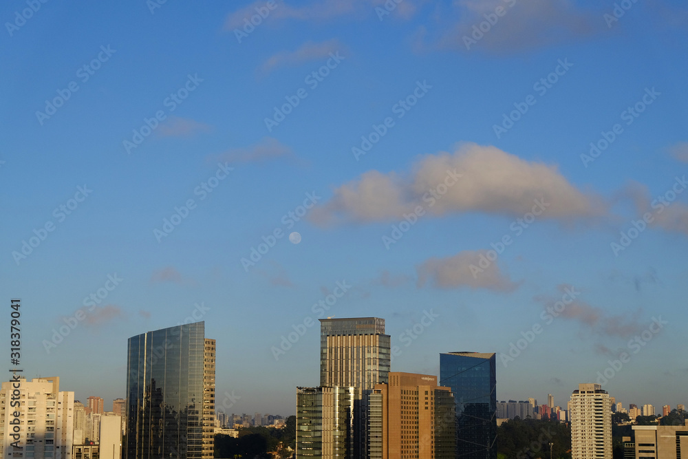 Flat cityscape with blue sky, white clouds and moon. Modern city skyline flat panoramic background. Urban city tower skyline illustration