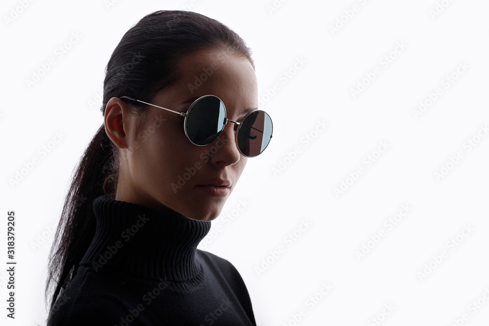 Young beautiful woman in black clothes and glasses on white background. Free space for text. Young beautiful woman in black clothes and glasses on white background. Free space for text.