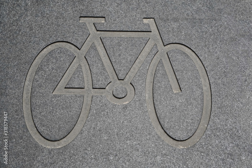 Bicycle symbol on the concrete roadway. Pictograph of a bicycle on the asphalt of a road marking a cycle lane next to the roadway. Bike icon on the road.