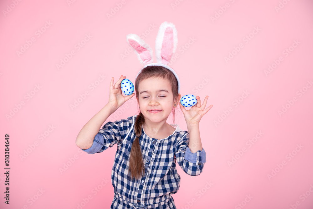 Portrait of a cute little girl with Easter eggs on a pink background. Portrait of a cute little girl with Easter eggs on a pink background.