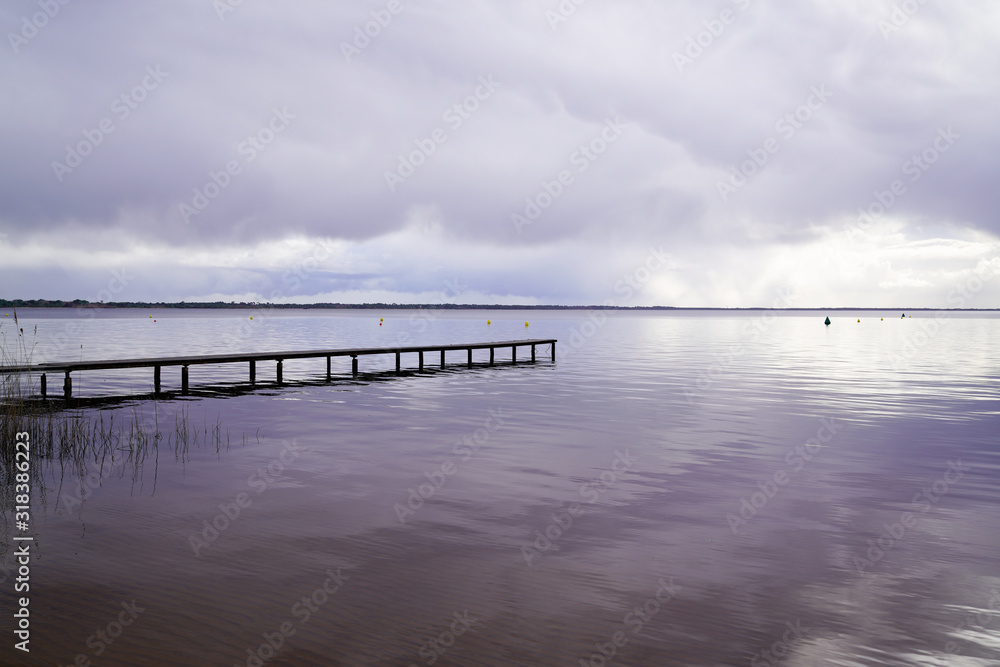wood access empty pontoon sunrise blue water winter on Lake Hourtin in Gironde france