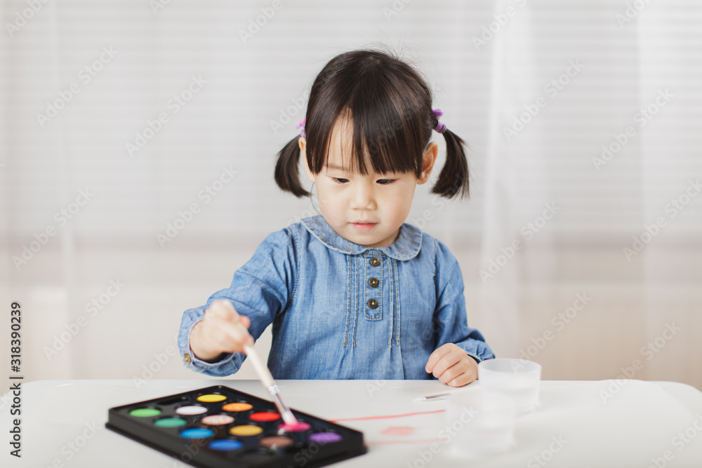 toddler girl practice watercolor paiting at home agianst white background toddler girl practice watercolor paiting at home agianst white background