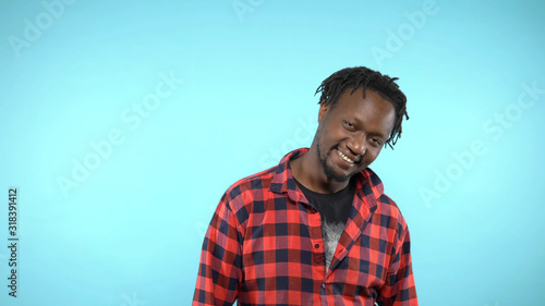 portrait of a stylish handsome African guy on blue background