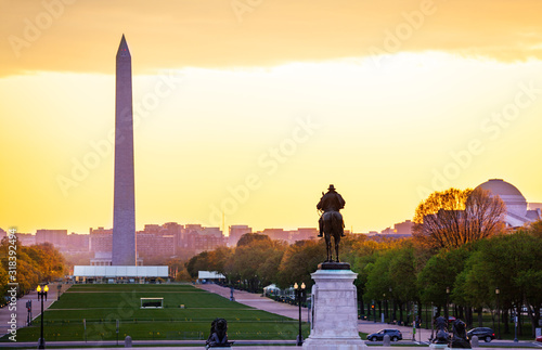 Ulysses S. Grant Memorial statue over National Mall and Washington Monument obelisk with yellow sunset on background