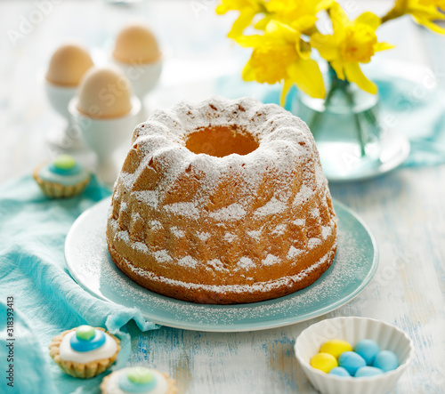 Fotografía Easter yeast cake sprinkled with powdered sugar on a turquoise plate