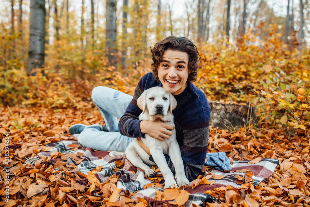Photo of handsome man and his dog spend time in the autumn forest. Photo of handsome man and his dog spend time in the autumn forest.