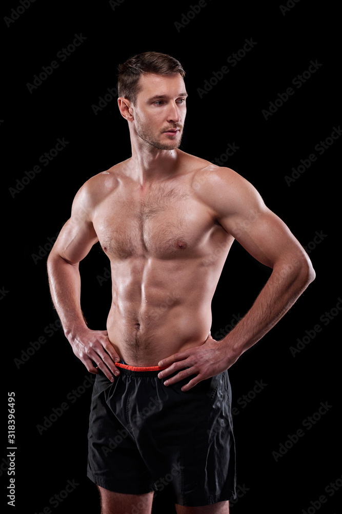 Fototapeta premium Young muscular shirtless male athlete keeping his hands on waist