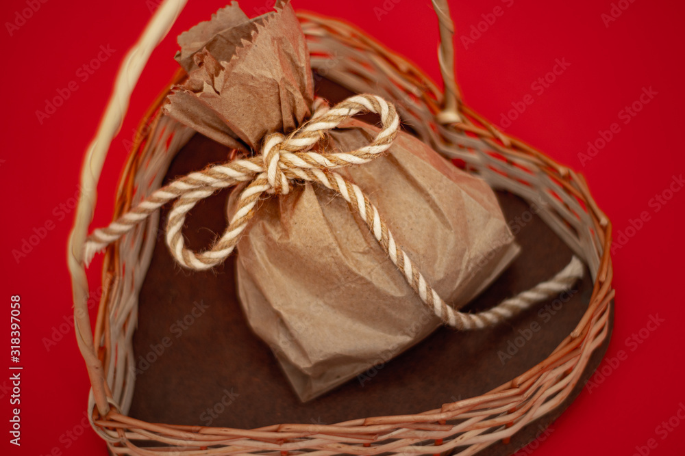 Bolsa de regalo sobre un corazón artesanal en fondo rojo