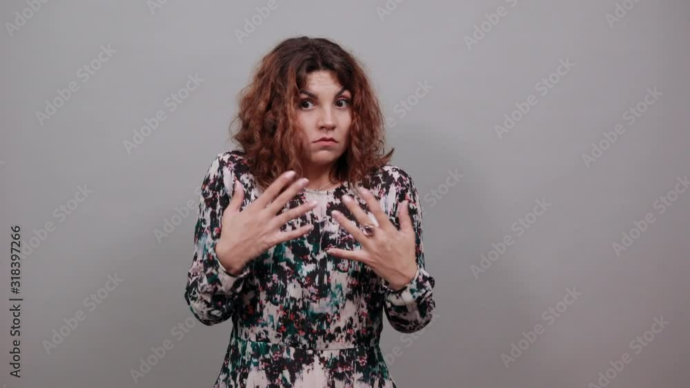 Charming happy caucasian young woman spreads hands, keeping hands on chest, looking at camera, smiling over isolated gray background in fashion shirt. Lifestyle concept Charming happy caucasian young woman spreads hands, keeping hands on chest, looking at camera, smiling over isolated gray background in fashion shirt. Lifestyle concept