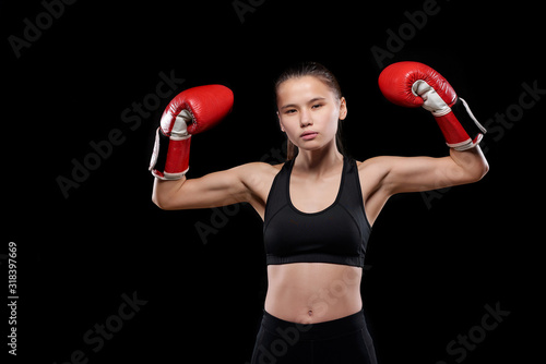 Young strong mixed-race sportswoman in activewear and boxing gloves