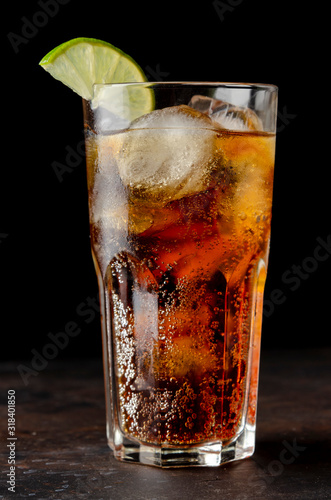 soda or cocktail with ice on table against black background