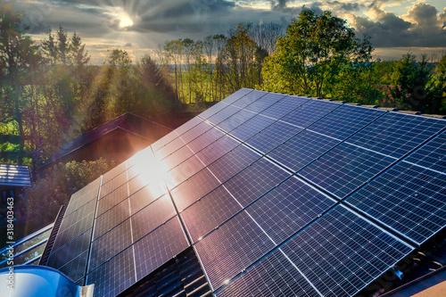 Solar panels and sunlight reflextions on the roof against blue sky background. Concept clean power energy.