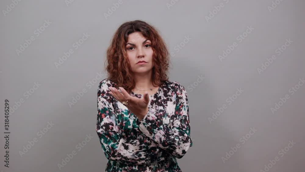 Disappointed brunette caucasian young woman showing at camera palm with nice signet, looking unhappy, spreads hands over isolated gray background in fashion shirt. Lifestyle concept Disappointed brunette caucasian young woman showing at camera palm with nice signet, looking unhappy, spreads hands over isolated gray background in fashion shirt. Lifestyle concept