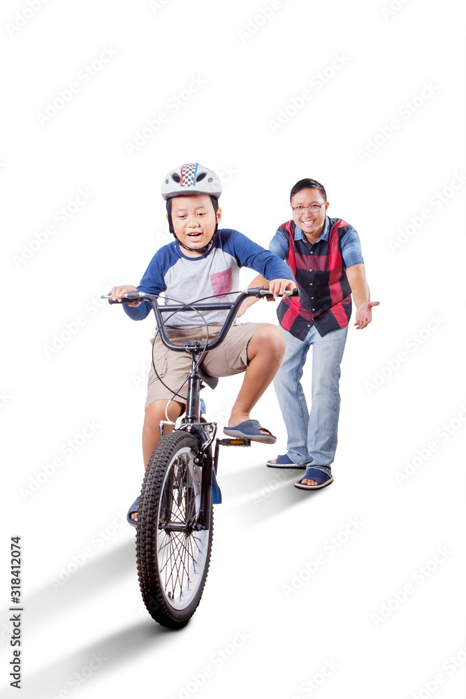 Asian boy riding a bike actively with his father Asian boy riding a bike actively with his father